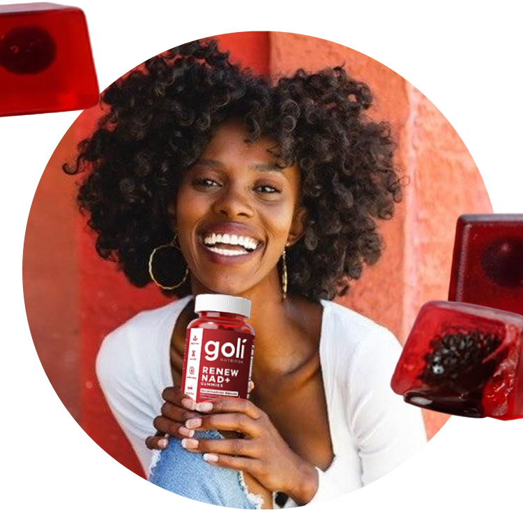 Woman smiling while holding a Goli gummy bottle